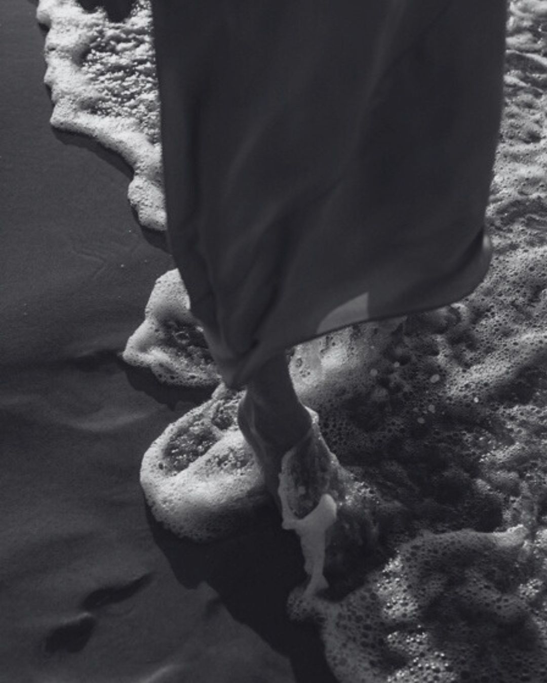 Frau geht barfuß in der Brandung