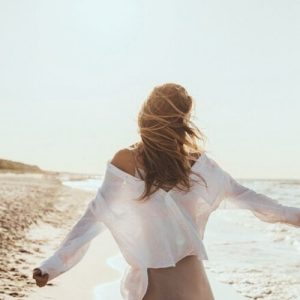 Frau am Meer gehend Frau geht am Meer im Wind entlang