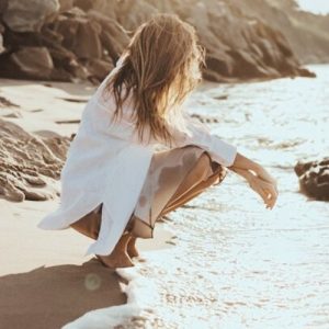 Frau am Strand Meer Frau hockt am Meer